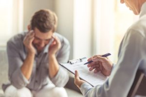 male patient works with addiction treatment professional during alcohol addiction treatment