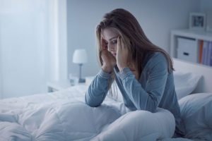 female struggles with sleep as she considers a chronic imsomnia treatment program