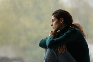 Woman looks out window and wonders if she needs dissociative disorder treatment