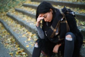 a woman sits on the steps and considers generalized anxiety disorder treatment