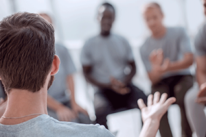 Man talks to others about his health in a group therapy program