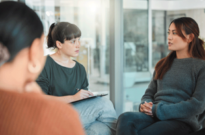 Woman listens intently while in shopping addiction treatment program