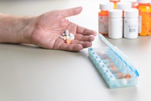 doctor prepares pills for a patient who is using medication assisted treatment